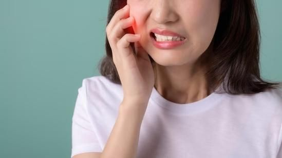 Mulher sentindo dor de dente e segurando o rosto