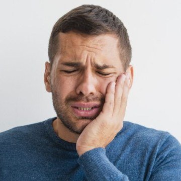 Homem com dor de dente intensa segurando o rosto